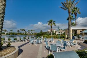 un patio con sillas y un lago con palmeras en Spacious Palm Coast Condo Balcony, Beach Access!, en Palm Coast