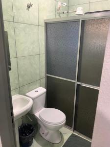 a bathroom with a toilet and a sink and a shower at Hotel Imigrantes - Várzea Grande in Várzea Grande