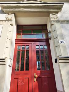 eine rote Tür an einem weißen Gebäude mit Fenstern in der Unterkunft *****Saxonia De Luxe***** Neue & Hochwertige 50qm² 2-Zimmer-Ferienwohnung in Chemnitz mit Parkplatz & wie zuhause Wohlfühlatmosphäre - My feel@home Apartment in Chemnitz in Chemnitz