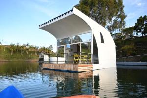 a floating house on a body of water at Casa Flotante La Trinidad in Guatapé