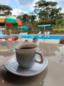 - une tasse de café assise sur une table près de la piscine dans l'établissement Hosteria Licalhe, 