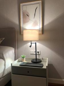 einen Tisch mit einer Lampe auf einem Nachttisch neben einem Bett in der Unterkunft The Black Cherry in Oviedo