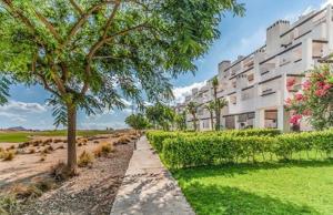 una pasarela frente a un edificio con un árbol en Vista al Golf, en Roldán