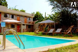 einen Pool vor einem Hotel mit Stühlen und Sonnenschirmen in der Unterkunft Ecolodge Huaca Piedra in Illimo
