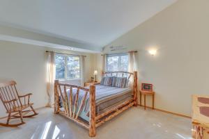 ビッグフォークにあるBigfork Village Retreat - 1 Mi to Flathead Lake!のベッドと椅子と2つの窓がある寝室