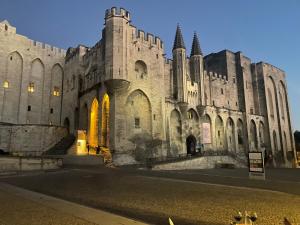 a large stone building with yellow lights on it at Chez Flo in Avignon