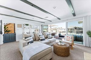 ein Wohnzimmer mit Sofa und Tisch in der Unterkunft Stunning BayVIEW Home with Epic Waterfront Views! in Newport Beach