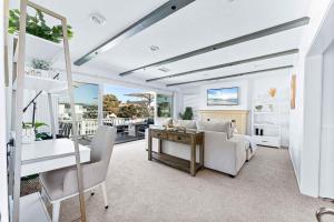 ein Wohnzimmer mit Sofa und Tisch in der Unterkunft Stunning BayVIEW Home with Epic Waterfront Views! in Newport Beach