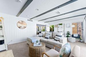 ein Wohnzimmer mit Sofa und Tisch in der Unterkunft Stunning BayVIEW Home with Epic Waterfront Views! in Newport Beach