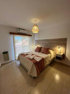 a bedroom with a large bed and a large window at Uptown City Apart La Falda in La Falda