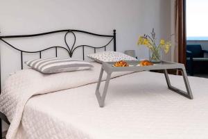 a white bed with a table on top of it at Apartments in Veli Losinj 26474 in Veli Lošinj