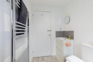 a white bathroom with a shower and a sink at Cheltenham in Cheltenham