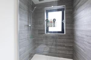 a bathroom with a shower with a glass door at Cheltenham in Cheltenham