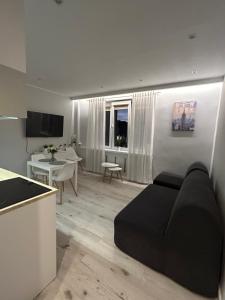 a living room with a black couch and a kitchen at Apartament na Dworcowej Centrum in Wrocław