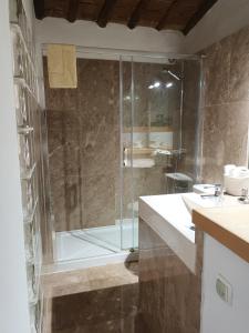 a bathroom with a shower with a glass door at Casa da Moeda in Évora
