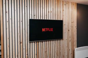 a television on a wooden wall with the words netflix at Stunning Centre of the city Apartment in Sheffield