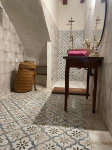 uma casa de banho com um lavatório e uma mesa em El Mirador de Benialfaqui, apartamento Els Olivers 