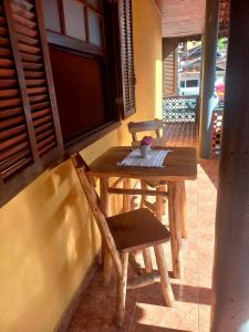 a wooden table and a chair on a porch at Suite Maromba in Núcleo Mauá