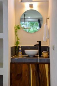 uma casa de banho com um lavatório e um espelho em Mangal Suites em Brisas de Zicatela