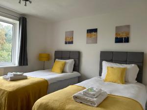 a bedroom with two beds with yellow sheets at Cosy 2 Bedroom House with Parking in Oxford in Kidlington