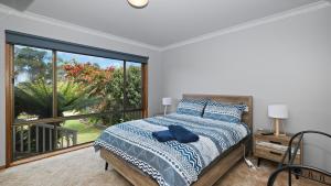 a bedroom with a bed and a large window at Marlo at the Beach in Marlo