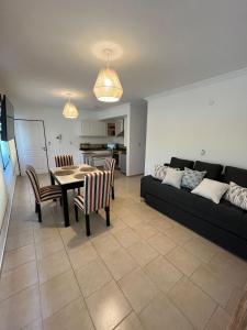 a living room with a couch and a table and chairs at Uptown City Apart La Falda in La Falda