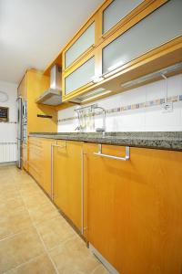 a large kitchen with wooden cabinets and a sink at GALIHOST - Piso con parking en pleno centro de Cambados in Cambados +10 photos