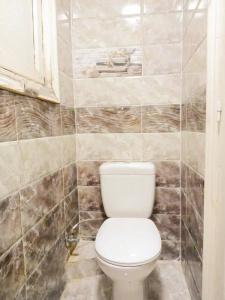 a bathroom with a white toilet in a tiled wall at LARA Maamoura beach Alexandria in Alexandria