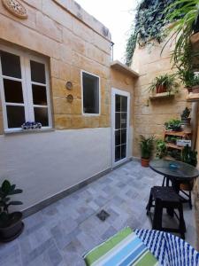 un patio con mesa y un edificio en Bizzilla Lodging Suite en Mqabba