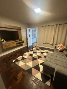 a living room with a couch and a checkered floor at Casa no Centro de Concórdia - SC in Concordia