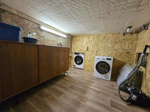 a laundry room with a washer and a washing machine at Le Cottage du Château in Faulx