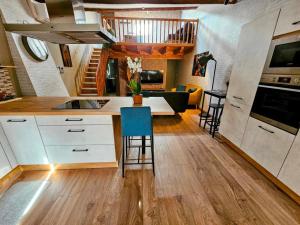 a kitchen with white cabinets and a table and chairs at Le Cottage du Château in Faulx