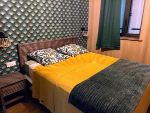 ein Schlafzimmer mit einem Bett mit einer gelben Decke in der Unterkunft Le Cottage du Château 