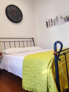 - une chambre dotée d'un lit avec une horloge murale dans l'établissement Casetta del Quadraro, à Rome