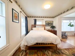 a bedroom with a bed and two windows at Whimsical apartment near downtown Winooski in Winooski