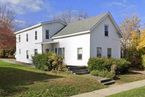 una casa blanca con techo gris en Whimsical apartment near downtown Winooski, en Winooski