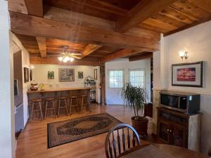 a large living room with wooden ceilings and a kitchen at Berkshire Inn in Groveland