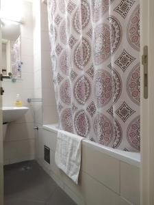 uma casa de banho com uma banheira e uma cortina de chuveiro em Apartment Tifani em Belgrado