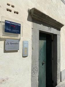 a sign on the side of a building with a door at Casa Vacanze La Romantica in Chiavenna