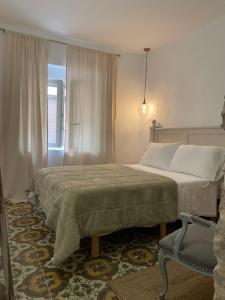um quarto com uma cama grande e uma cadeira em El Mirador de Benialfaqui, apartamento Els Olivers 