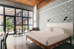 a bedroom with a bed and a wall of windows at Wythe Hotel in Brooklyn