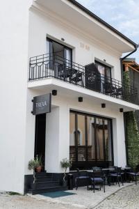 a white building with tables and chairs in front of it at Treva Hotel in Prizren