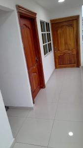 a room with two wooden doors and a white floor at Apartahotel Cartagena in Cartagena de Indias
