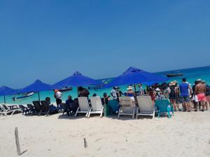 a group of people on a beach with chairs and umbrellas at Apartahotel Cartagena in Cartagena de Indias
