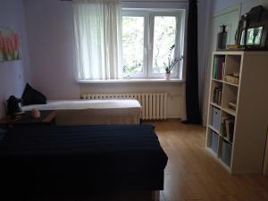 a bedroom with a bed and a window and a book shelf at Apartament Parterowy in Poznań