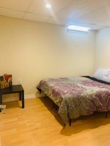 a bedroom with a bed and a table in a room at Finished 2 BR Apartment in an Upscale Area of Ajax in Ajax