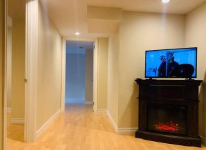 a living room with a fireplace and a flat screen tv at Finished 2 BR Apartment in an Upscale Area of Ajax in Ajax