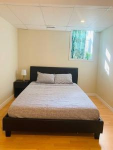 a bedroom with a bed in a room with a window at Finished 2 BR Apartment in an Upscale Area of Ajax in Ajax