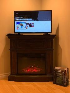 a flat screen tv sitting on top of a fireplace at Finished 2 BR Apartment in an Upscale Area of Ajax in Ajax