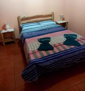 a bed with two pairs of robes on it at Suite Maromba in Núcleo Mauá